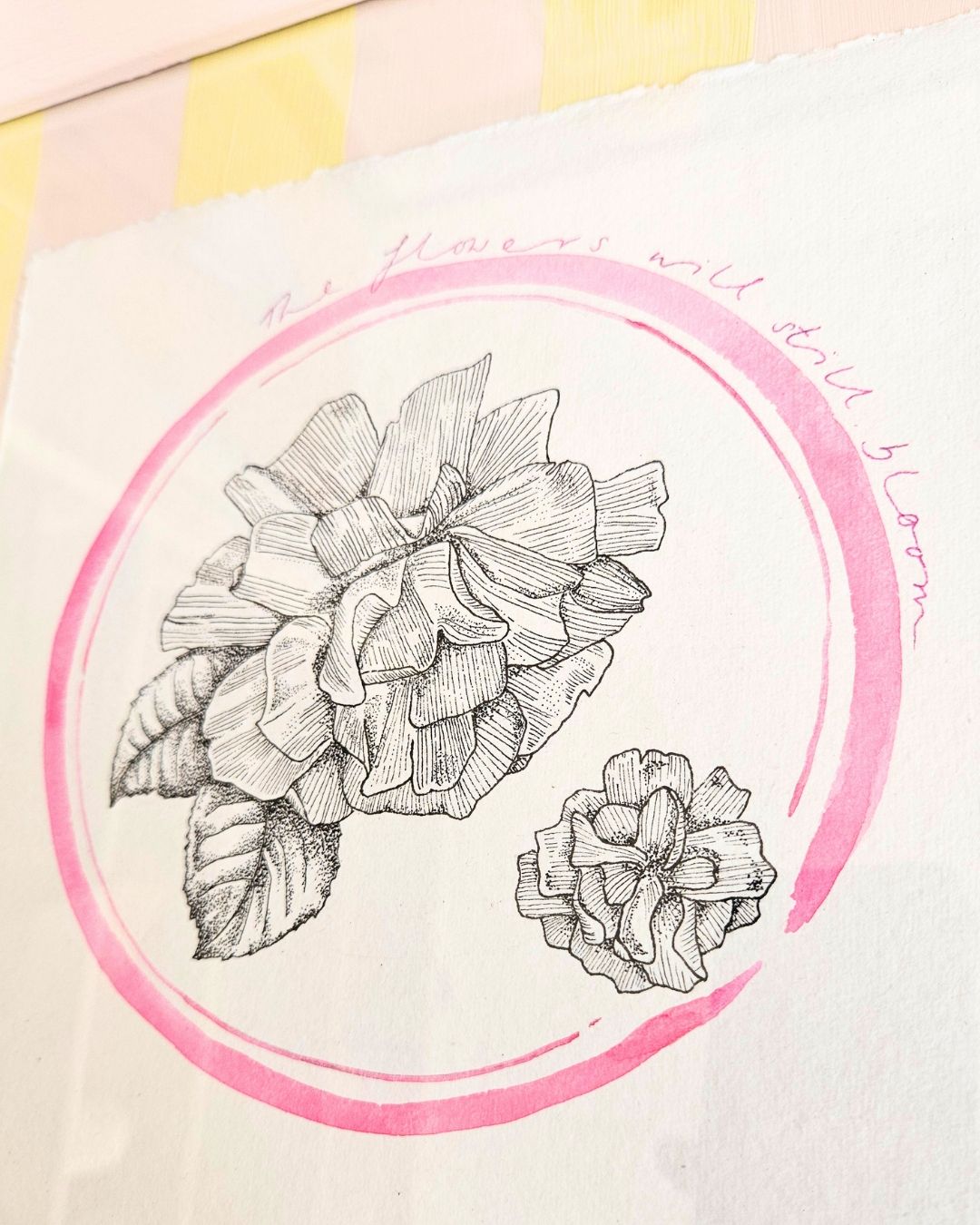 Black and white rose illustration in a painted pink circle