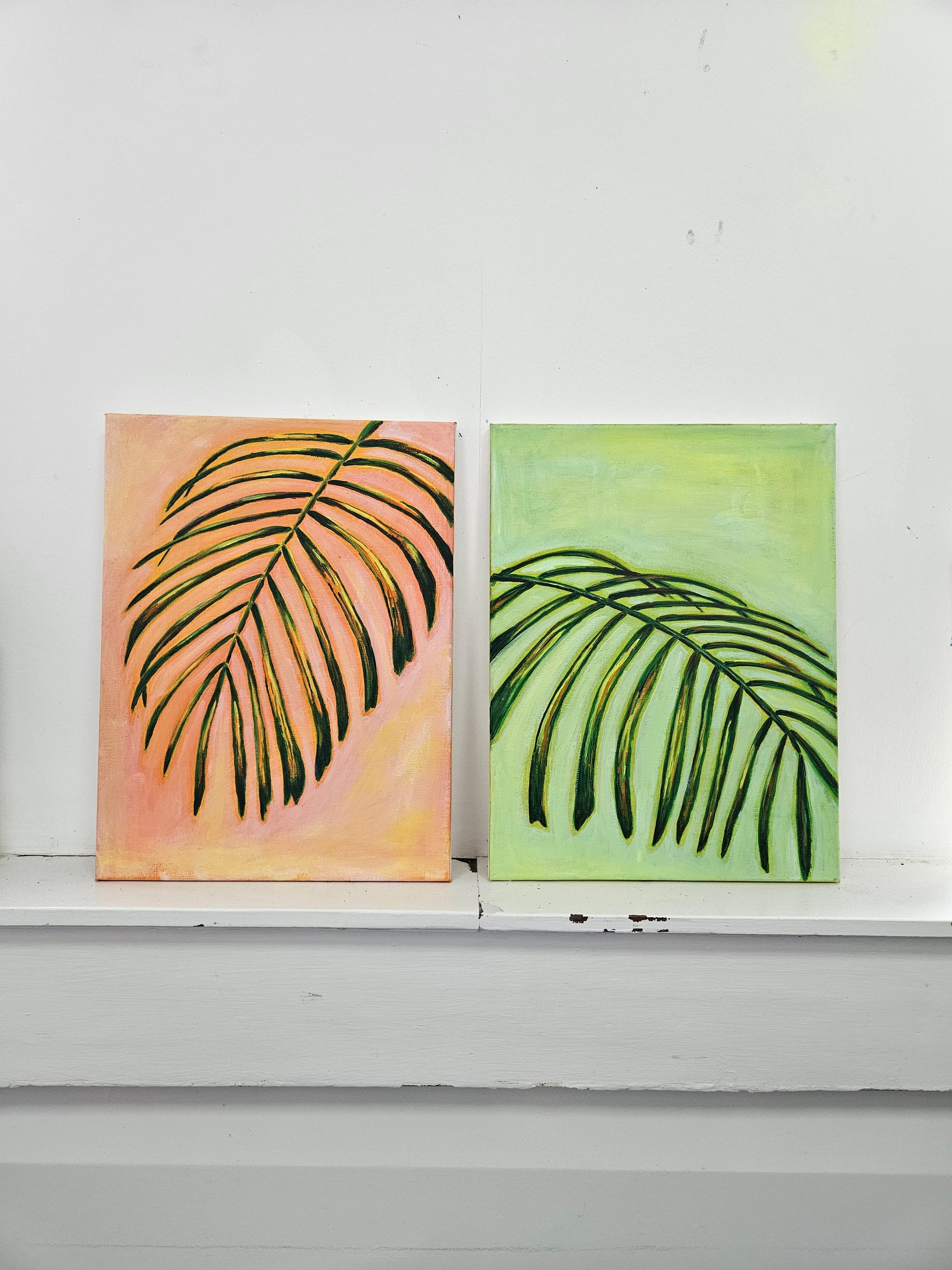 Two wall art pieces with leaf designs on a white background
