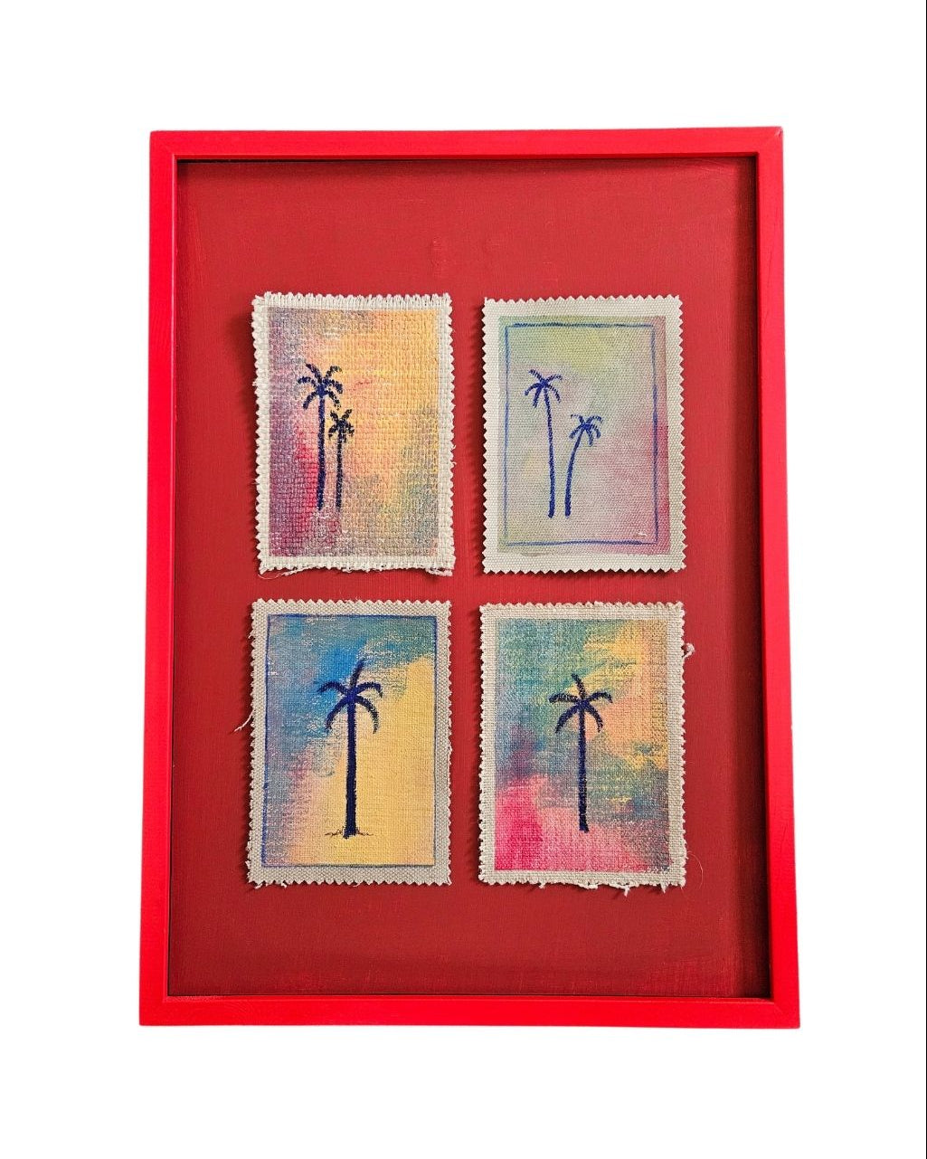 Four small paintings of palm trees on fabric, framed in a red frame