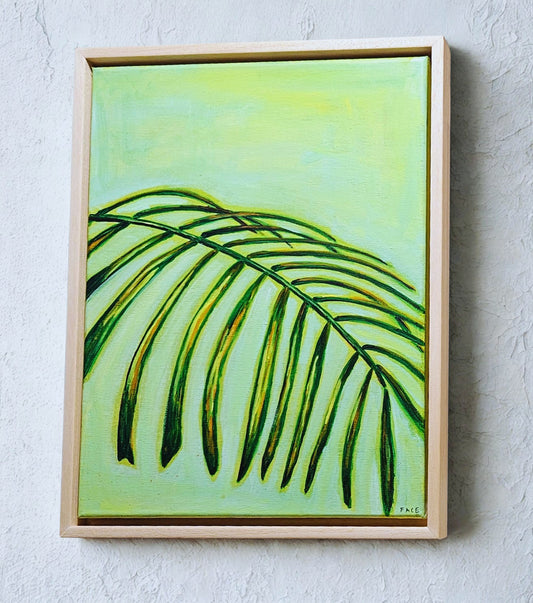 Framed artwork of a green leaf on a light green background