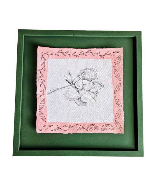 Framed artwork of a magnolia illustration with pink border and green frame