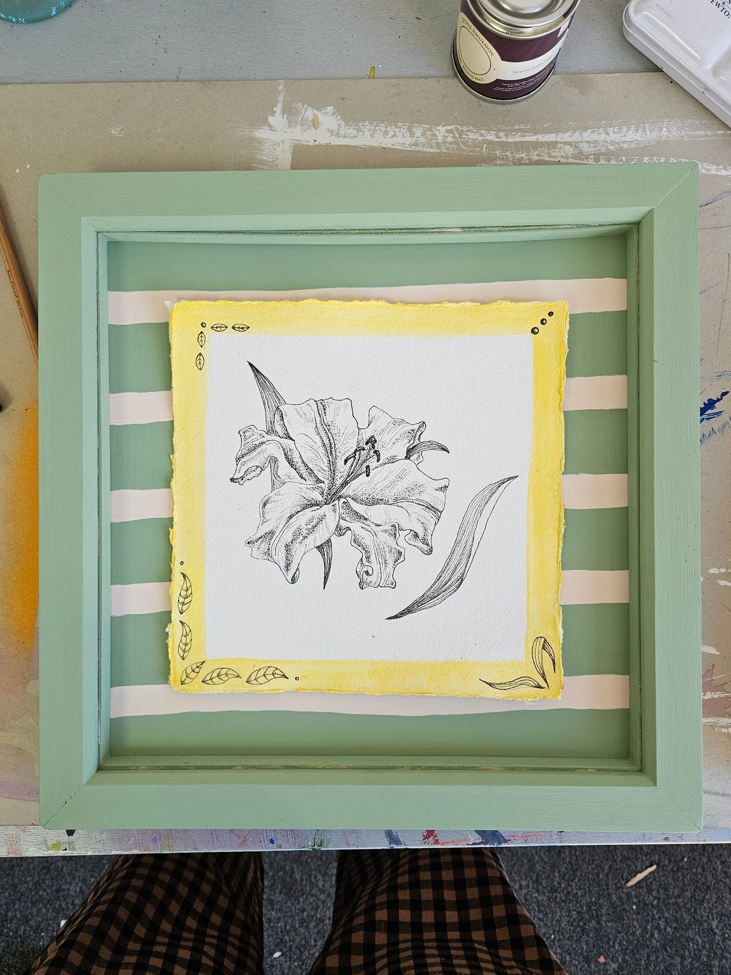 Framed artwork with a illustration of a Lily on a striped background